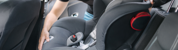 Installation d’un siège auto bébé Isofix dans une voiture par un jeune père