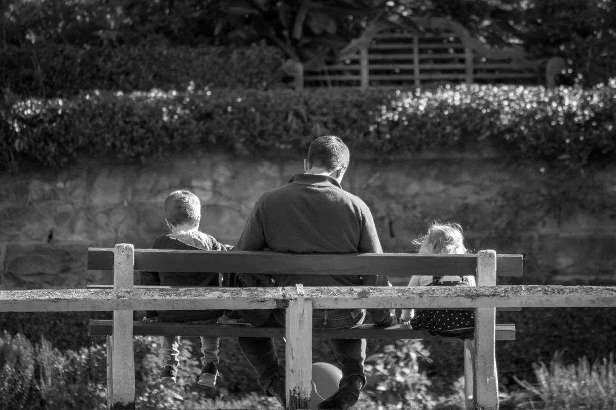 Père avec ces deux enfants sur un banc