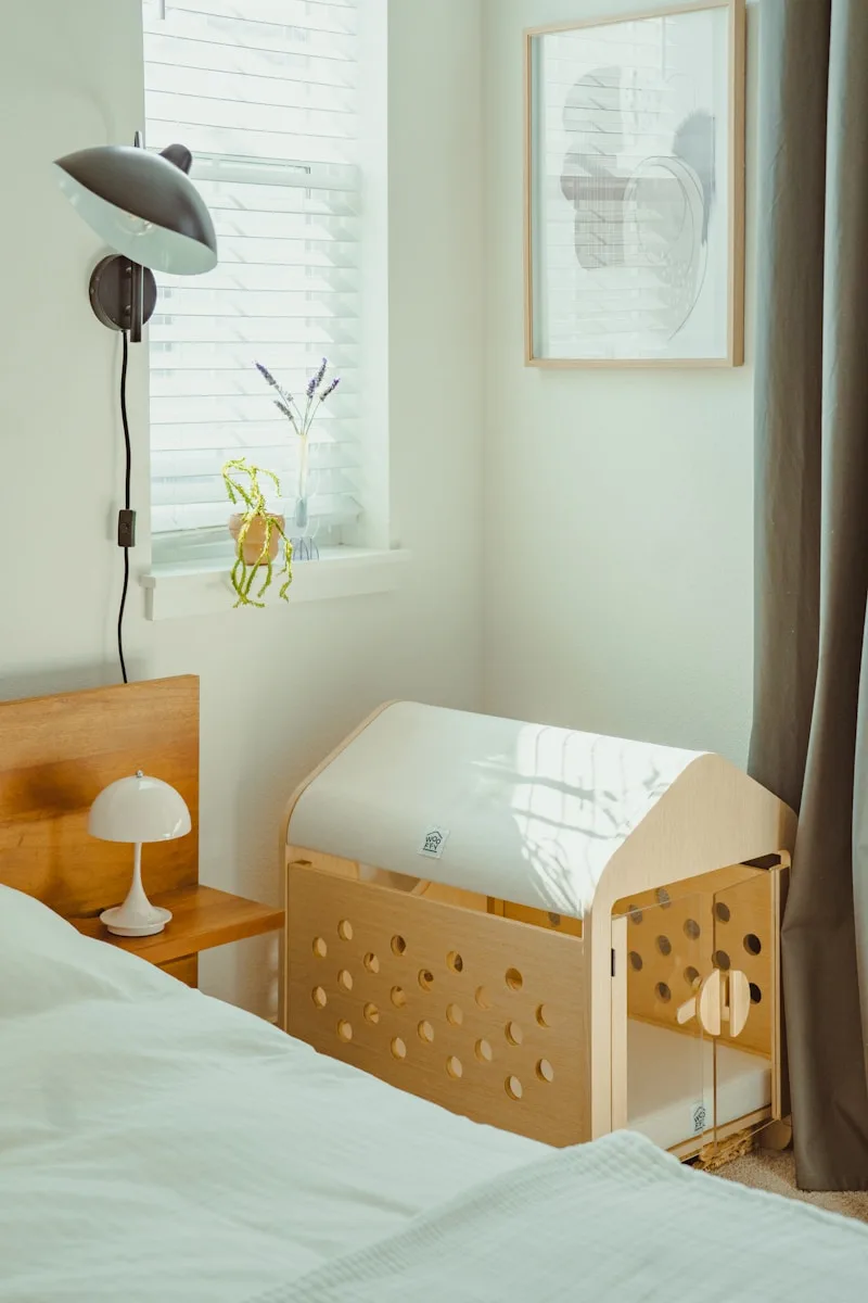 Wooden baby crib next to a bed in a room.