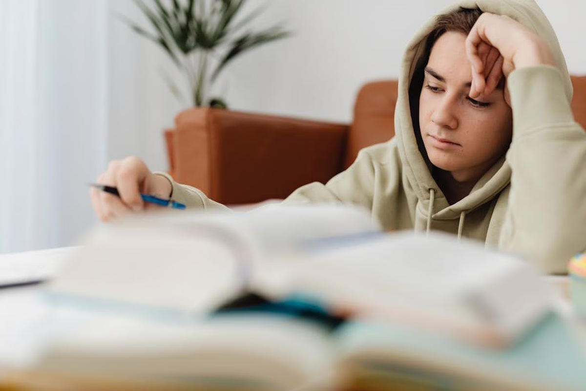 Eleve de troisieme revisant pour le brevet 2026 sur un cahier avec calculatrice