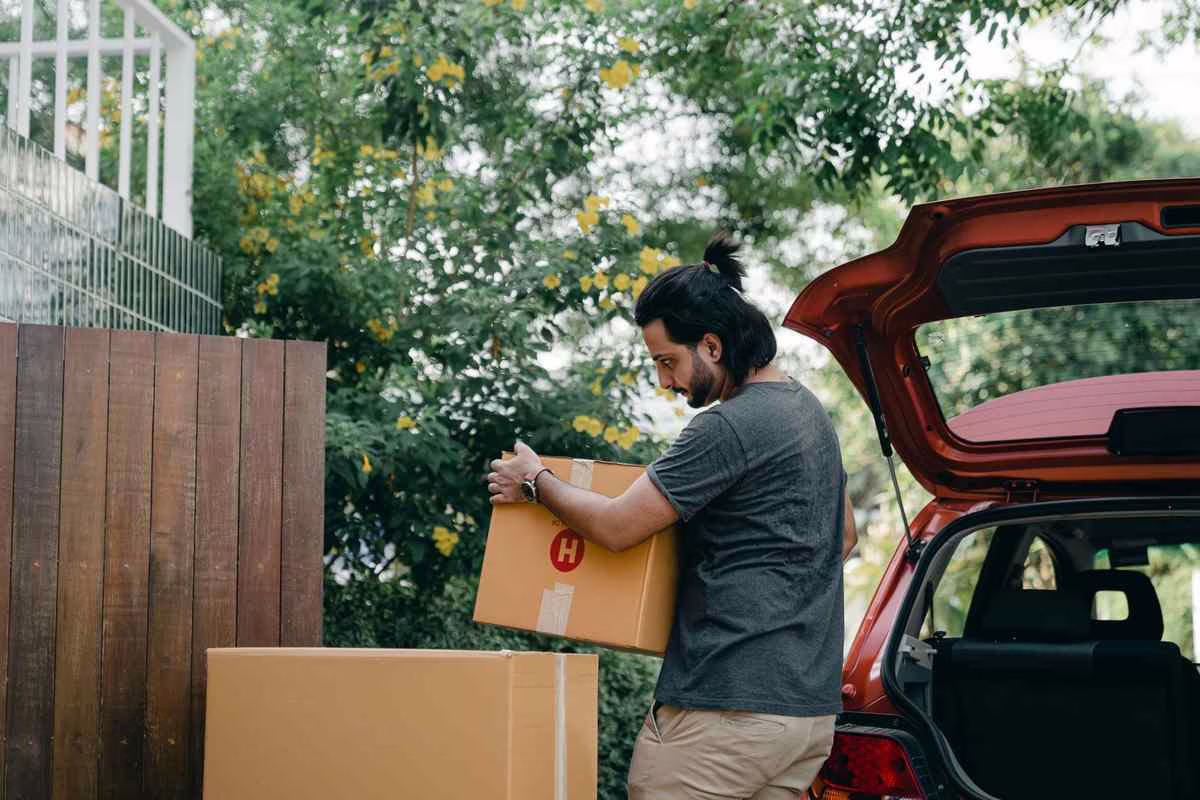 Un jeune étudiant avec ses cartons de déménagement, illustrant l’aide à la mobilité Parcoursup pour un changement d’académie