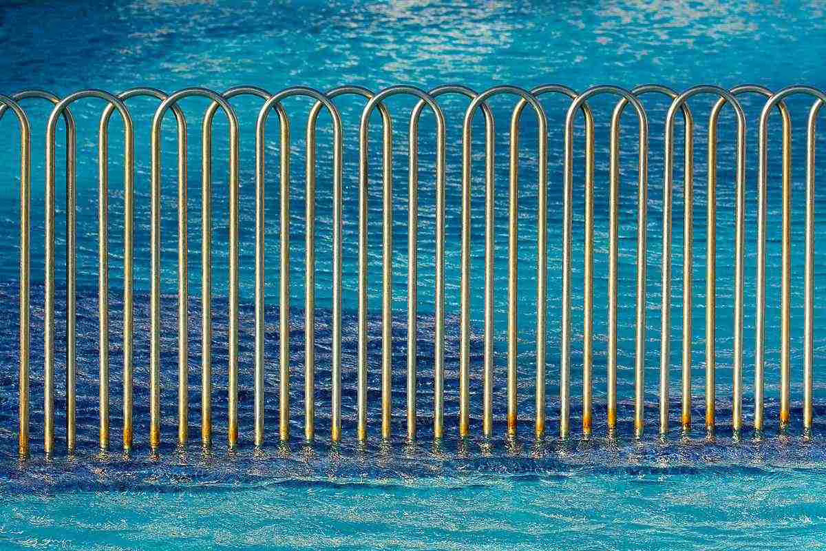 Barrière de sécurité transparente installée autour d'une piscine enterrée dans un jardin familial