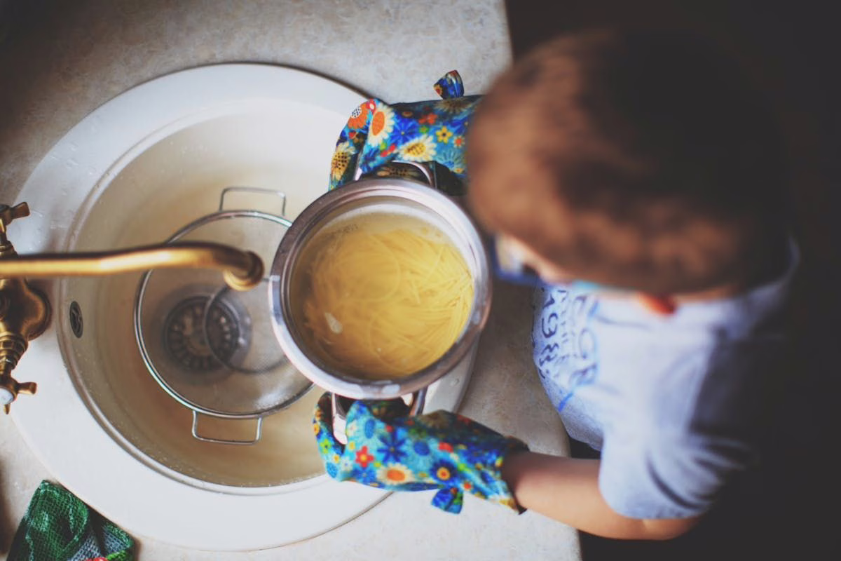 Scène de cuisine domestique, illustrant le risque de brûlure chez l'enfant et les premiers gestes à connaître