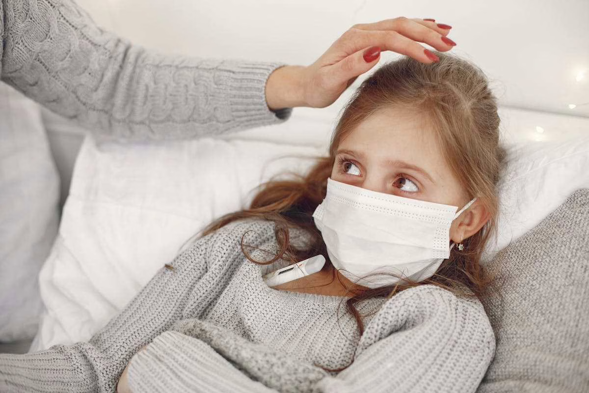 Mère prenant la température de son enfant malade allongé dans son lit à la maison, congé pour enfant malade