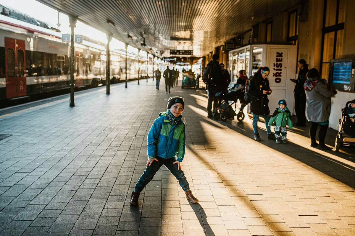 Enfant seul avec sa valise sur un quai de gare, prêt à voyager en train