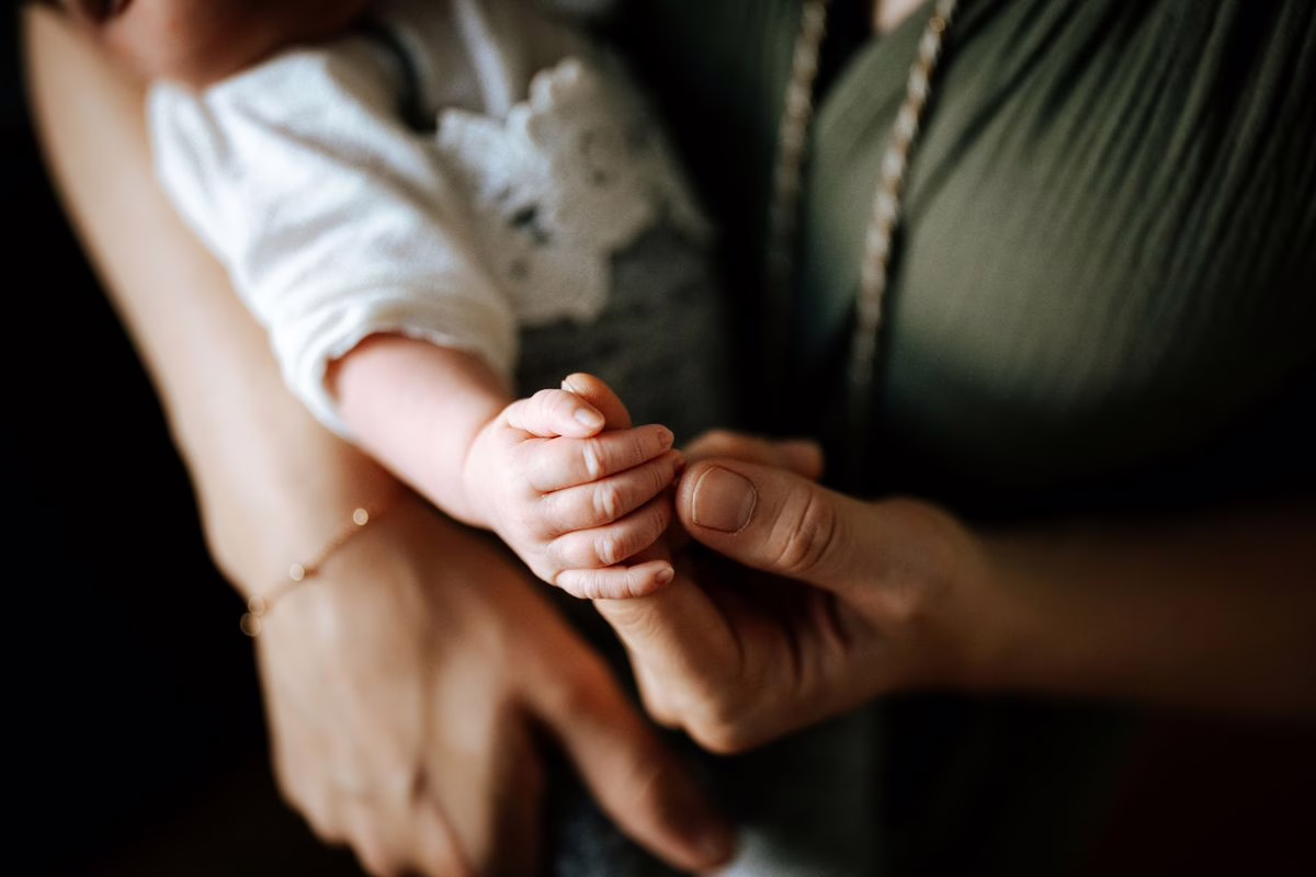 Parent tenant un nourrisson le long de l'avant-bras, position de départ des gestes de désobstruction en cas d'étouffement