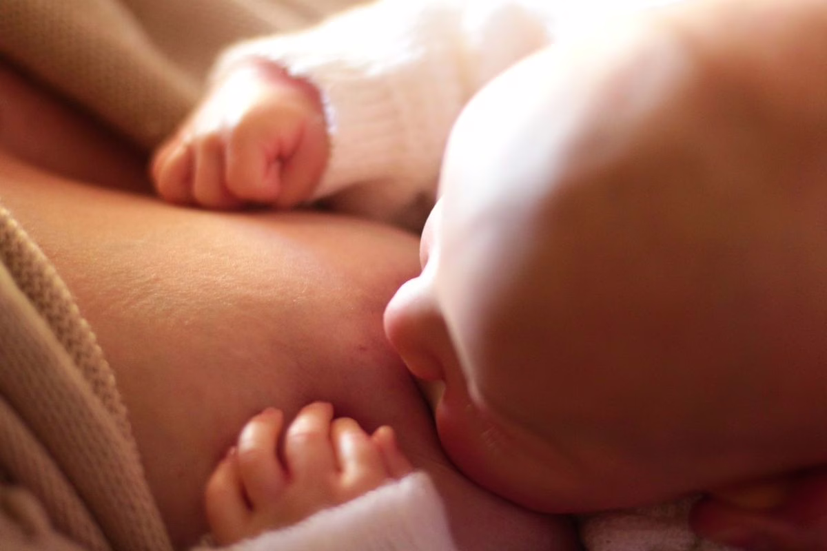 Un bébé ouvre la bouche et tire la langue pendant un examen doux réalisé par un professionnel