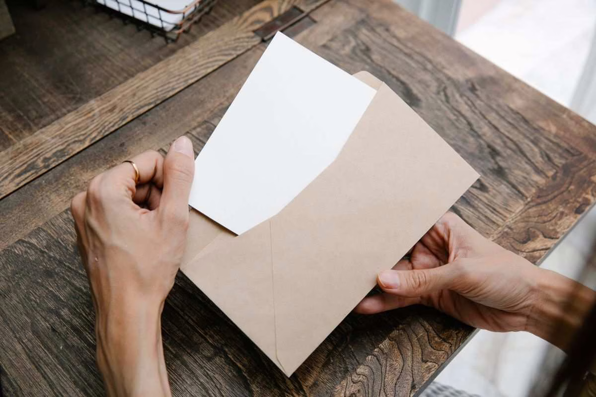 Parent assis à un bureau lisant un courrier de la CAF avec un ordinateur portable, démarche de médiation administrative