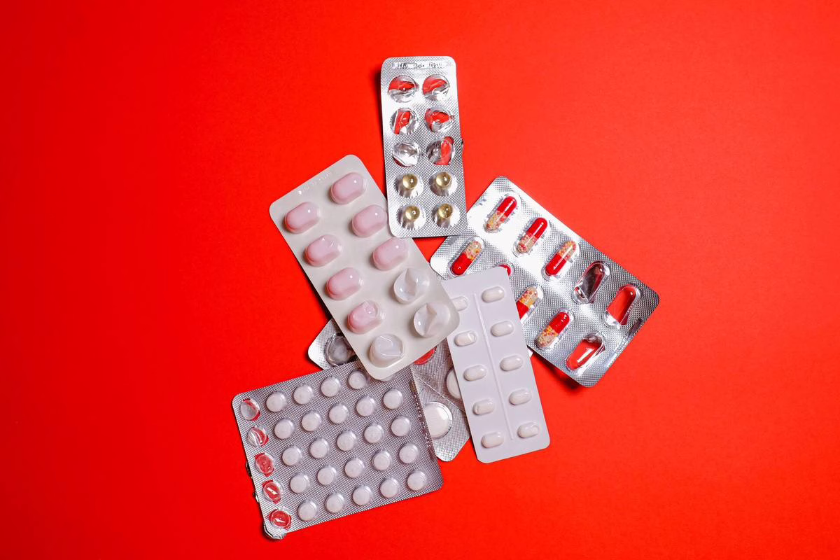 Boîtes de médicaments et comprimés posés à portée de main, illustration de la prévention de l'intoxication aux médicaments chez l'enfant