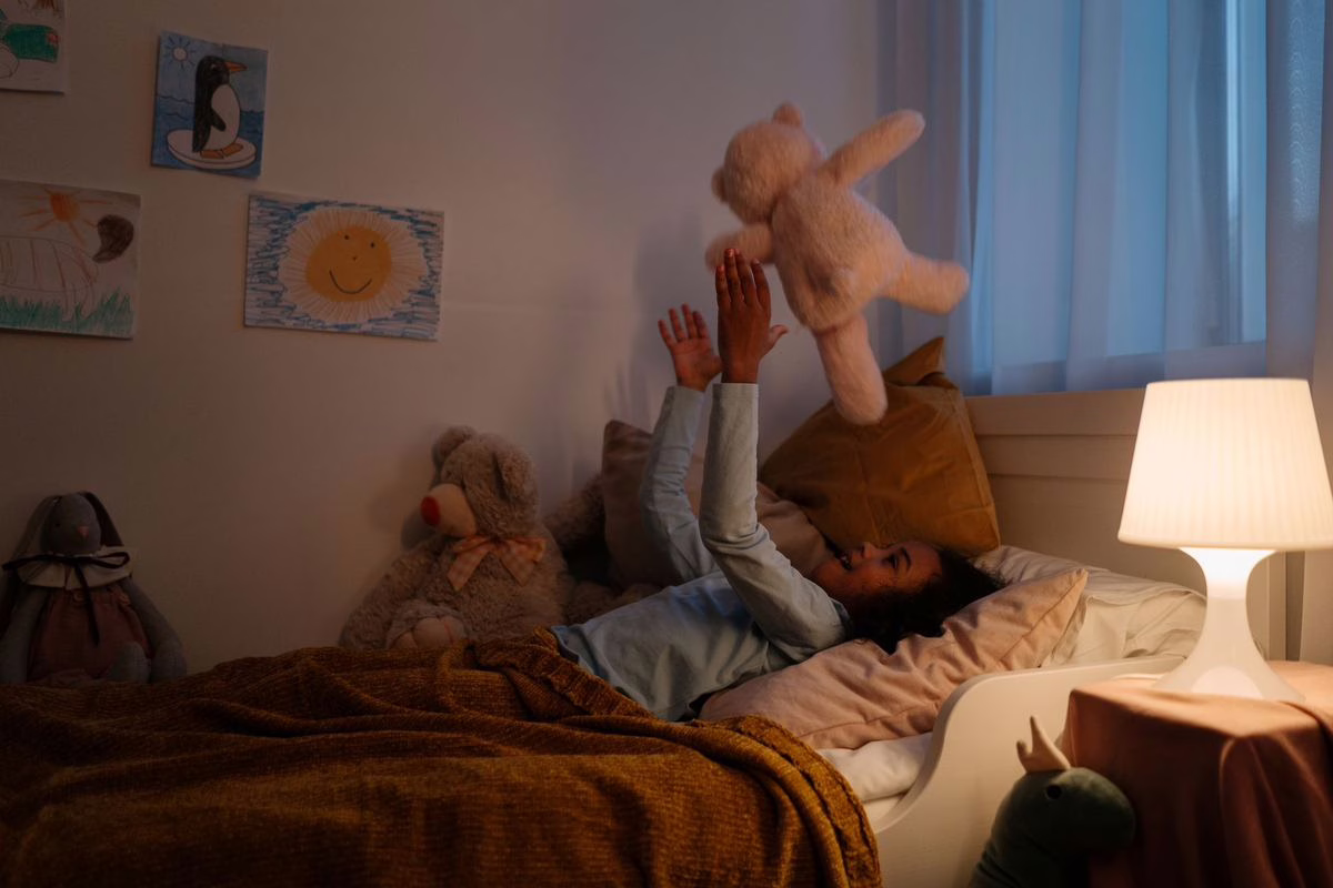 Enfant au coucher dans une chambre tamisée, illustration de la peur du noir