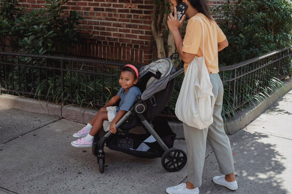Parent avec poussette canne et jeune enfant en ville