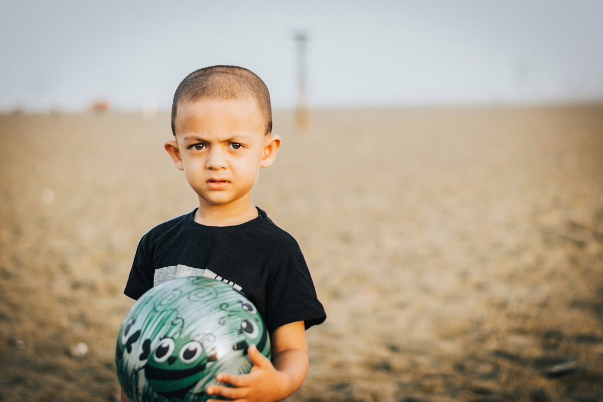 Enfant jouant avec un ballon de plage l'été, jouet concerné par le rappel ballon de plage TEDi