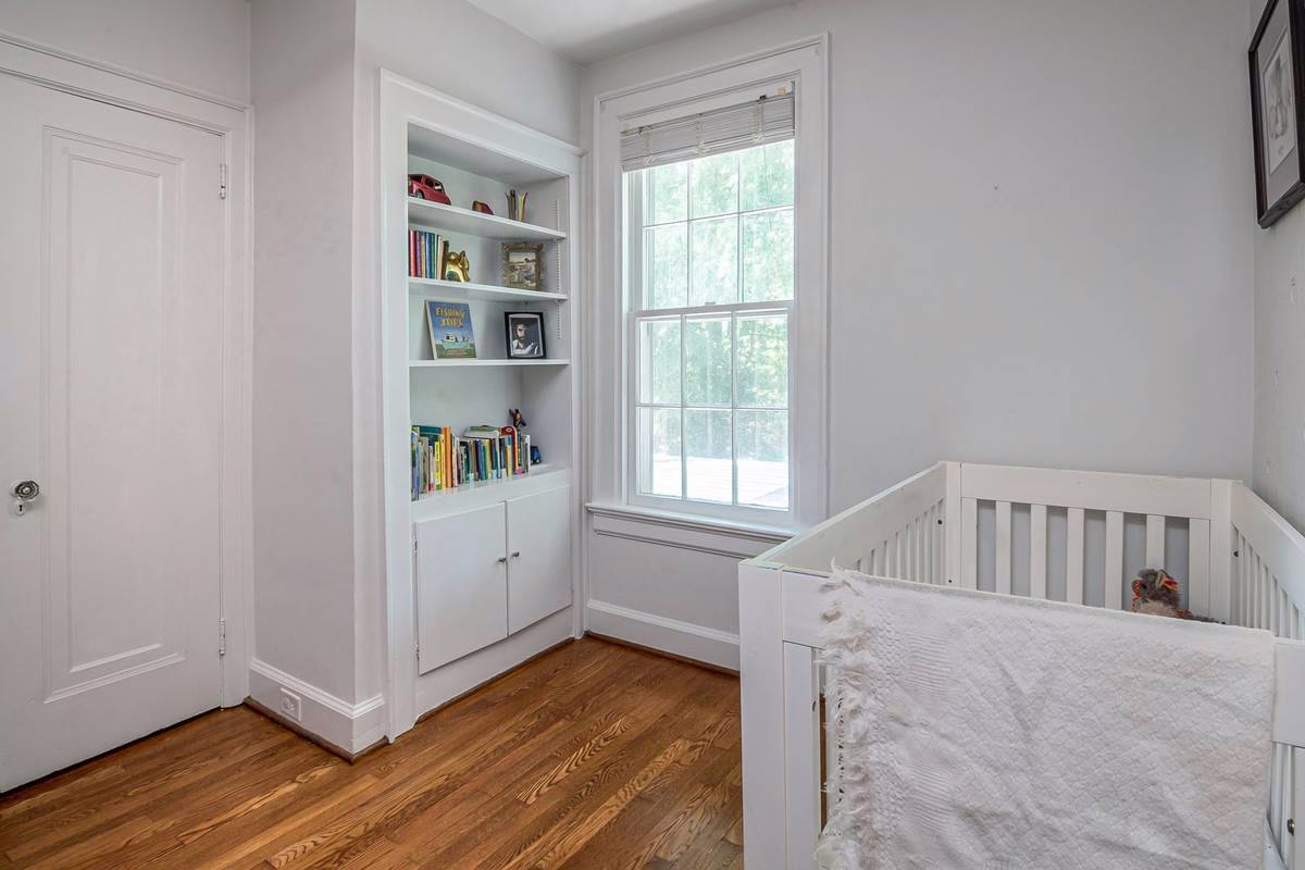 Chambre de bebe avec lit a barreaux pres de la fenetre