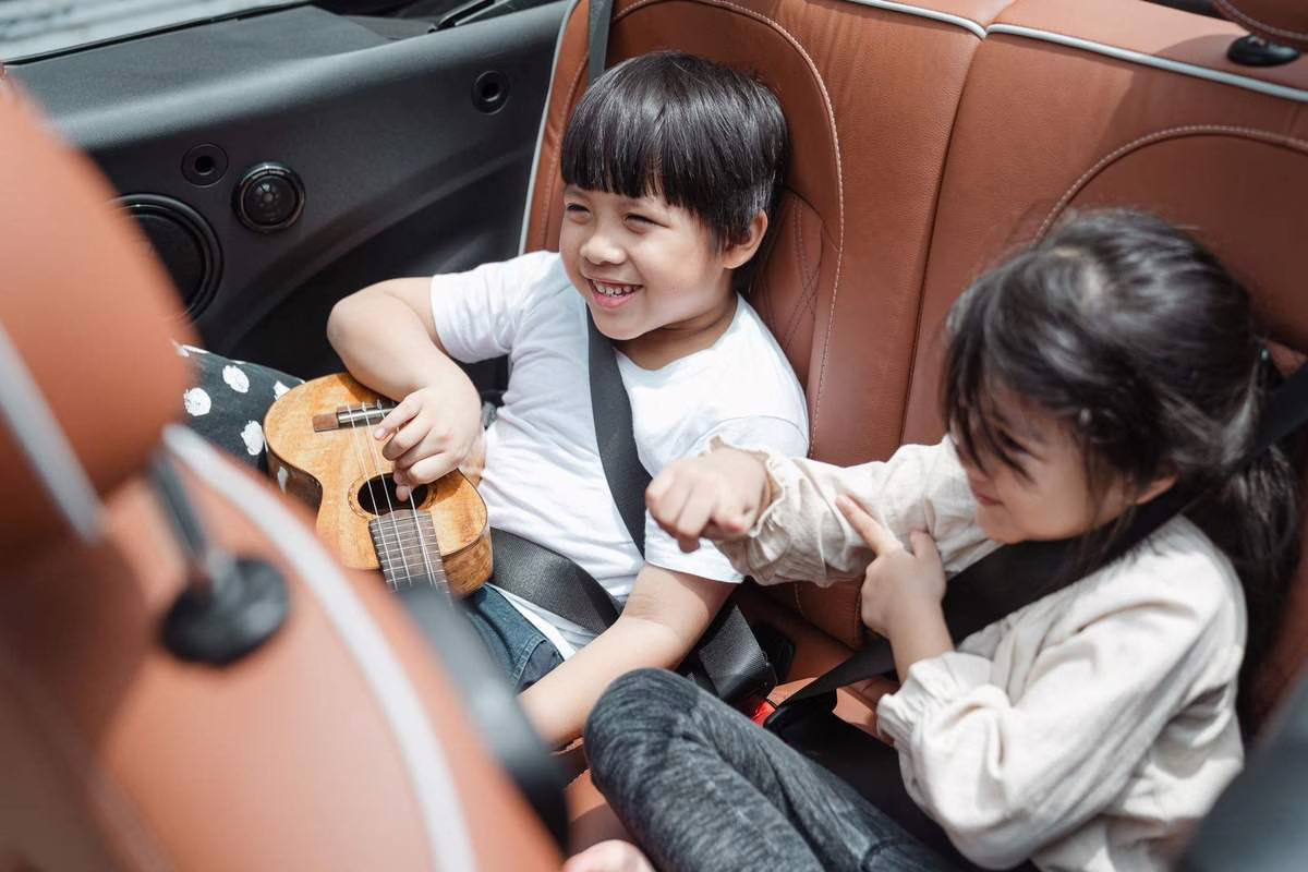 Une famille en voiture sur la route des vacances, un enfant attaché à l’arrière lors d’un trajet en voiture estival