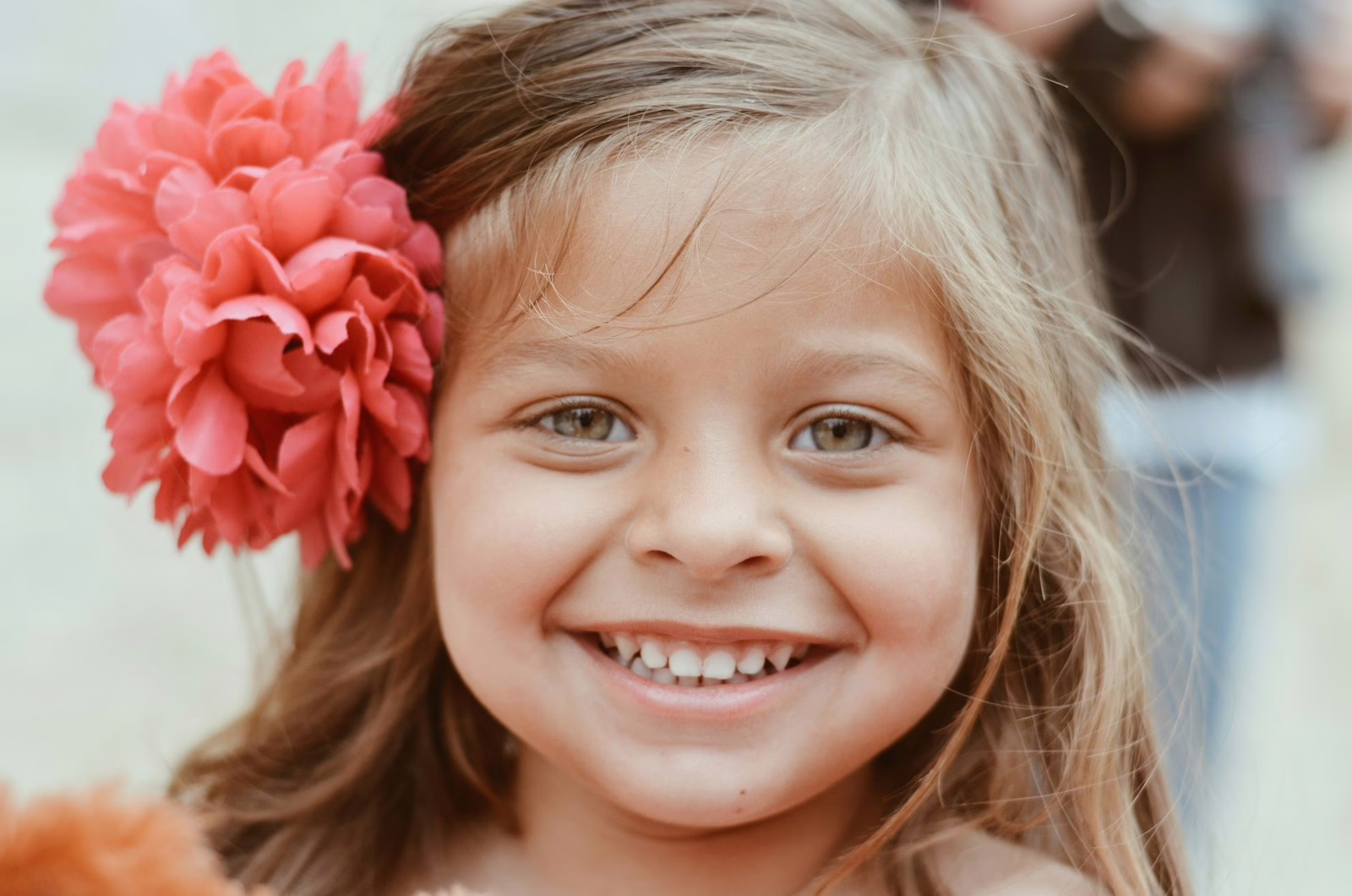 Petite fille souriante avec une fleur, illustration des prénoms anciens pour fille et garçon
