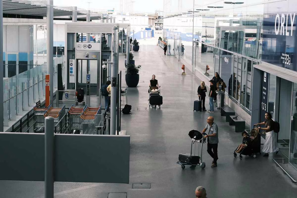 Une famille avec un enfant dans un aéroport, valises à la main, prête à voyager à l’étranger cet été