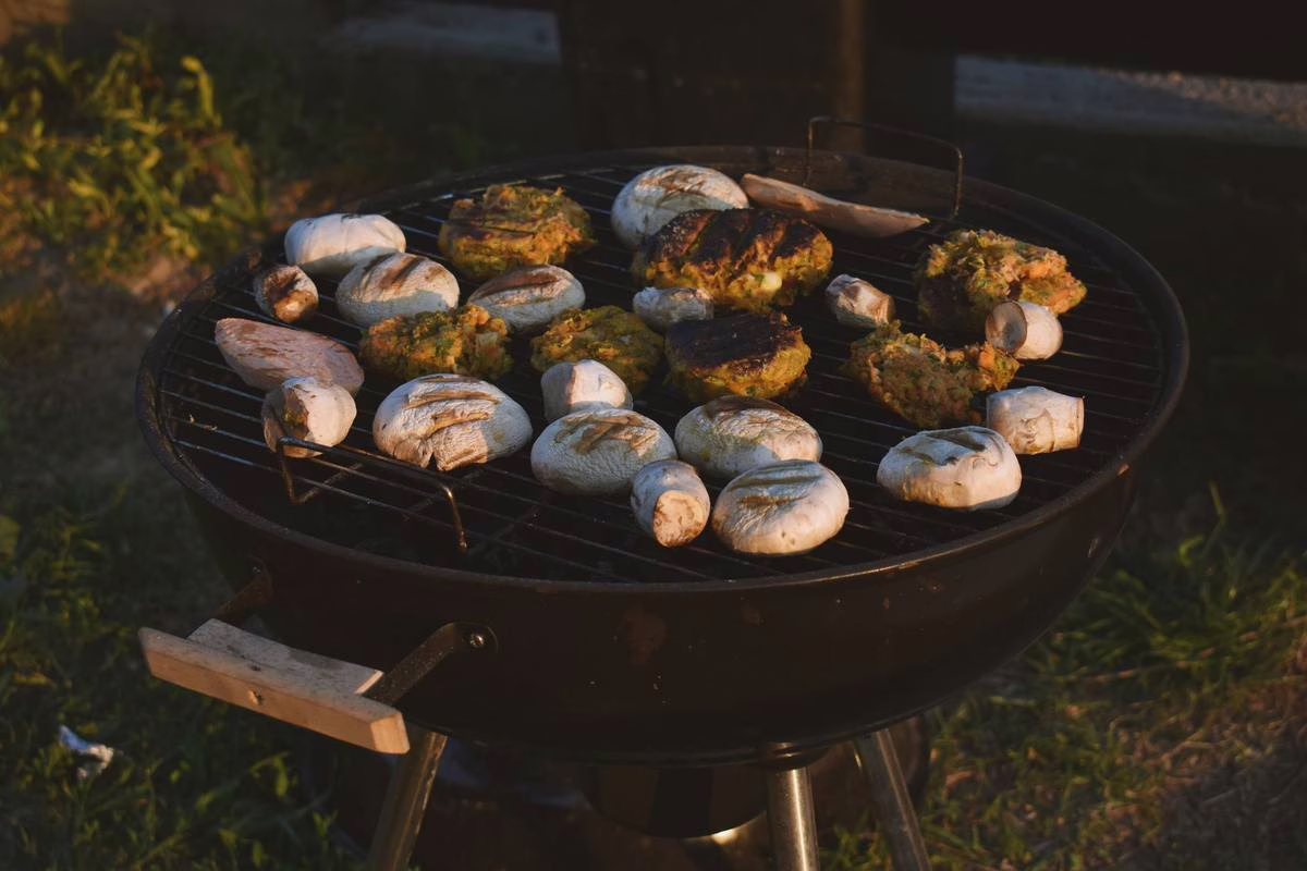 Barbecue allume dans un jardin l'ete, source frequente de brulure de barbecue chez les enfants