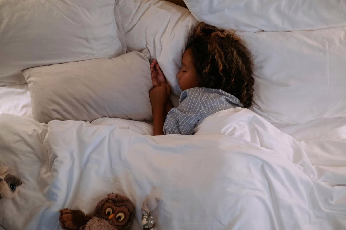 Jeune enfant endormi paisiblement dans son lit, sujet du bruxisme nocturne et du grincement de dents