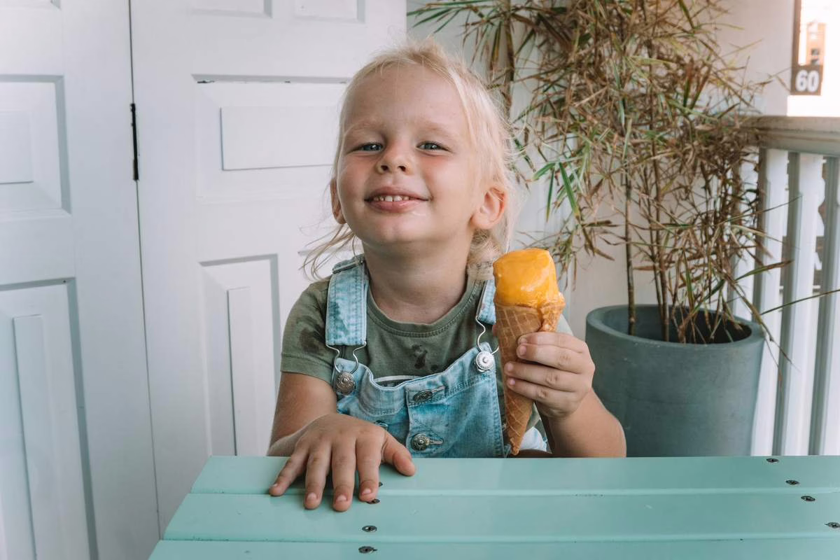 Enfant qui mange une glace l'ete, illustrant l'impact du sucre sur les dents des enfants