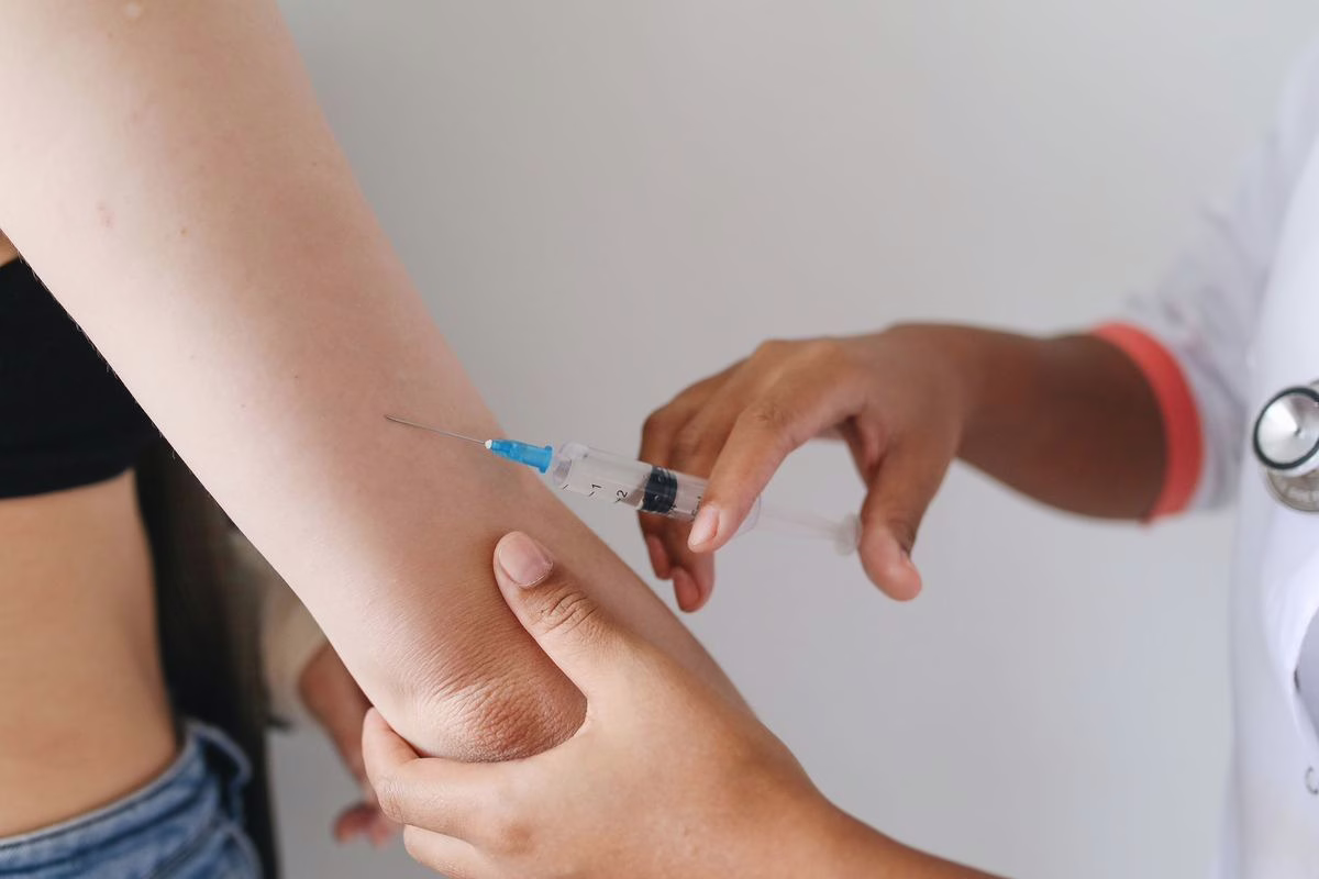 Bebe dans les bras d'un parent lors d'une consultation de vaccination chez le pediatre