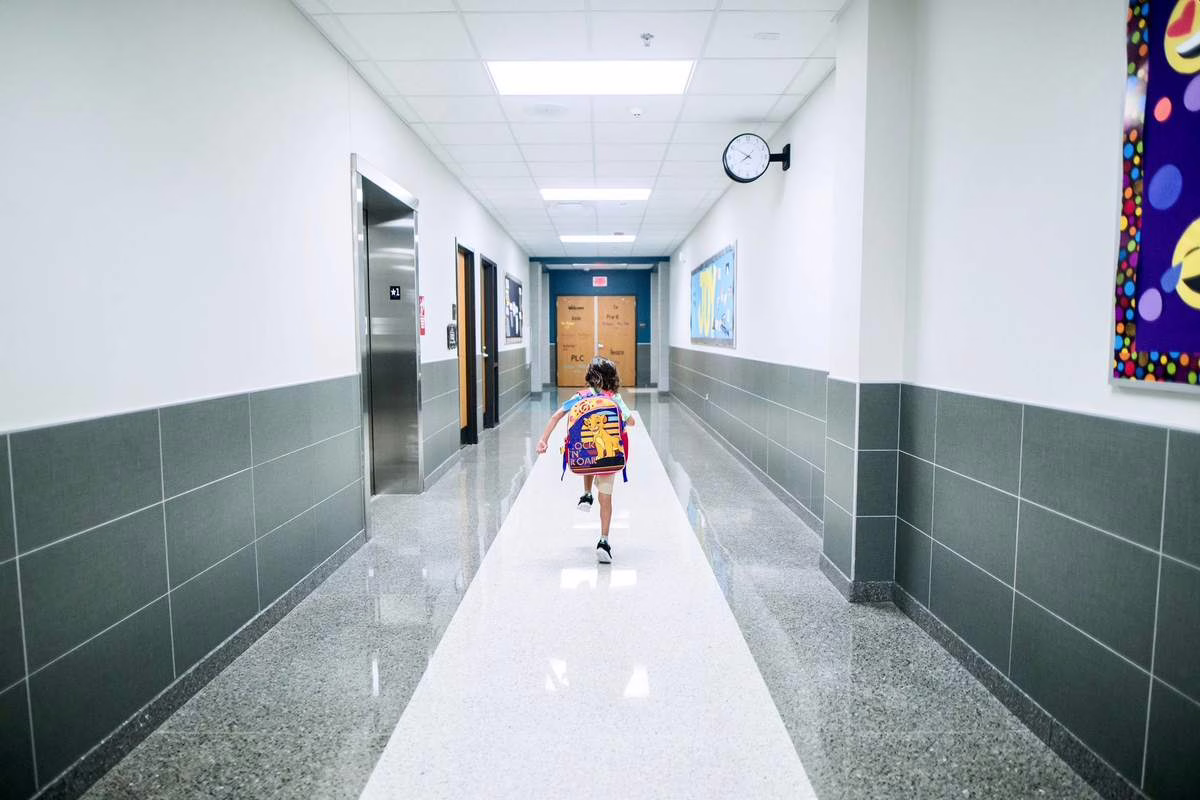 Enfant portant un cartable sur le dos en marchant vers l'ecole le matin