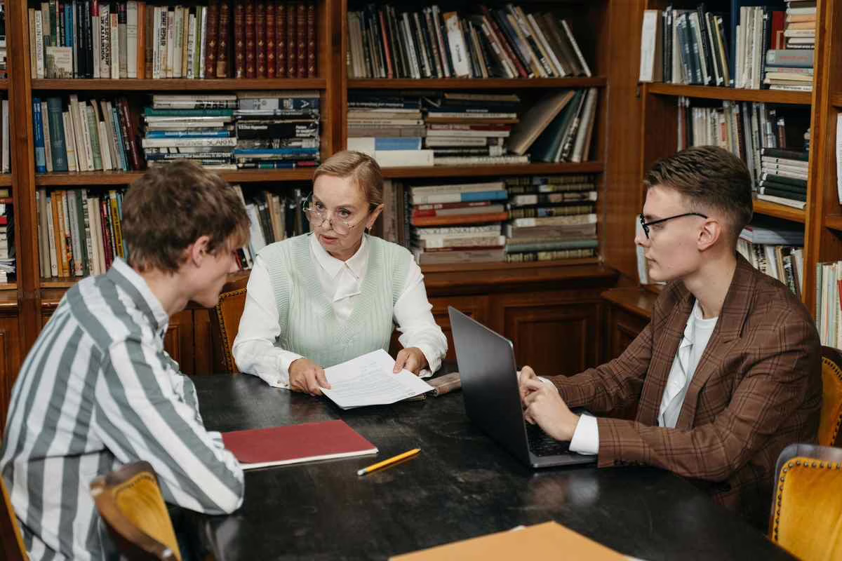 Un entretien entre des parents et une enseignante autour d'une table dans une salle de classe