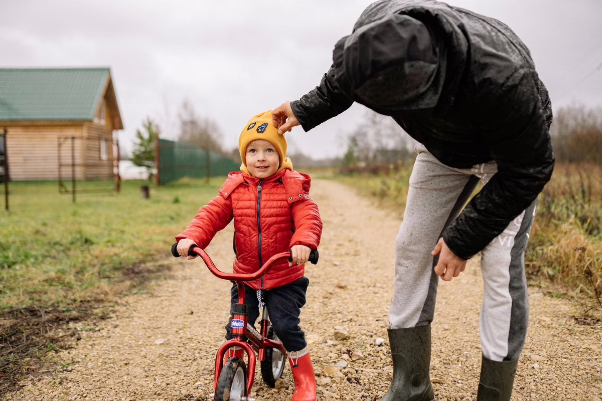 Parent et jeune enfant à vélo sur un chemin de campagne, usage type d'une remorque vélo enfant