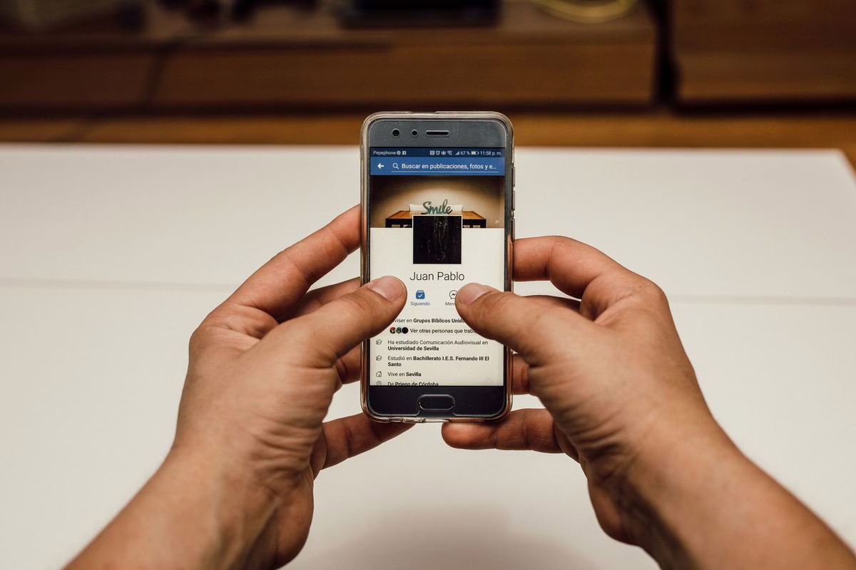 Un adolescent consulte les réseaux sociaux sur son smartphone, assis dans le salon familial