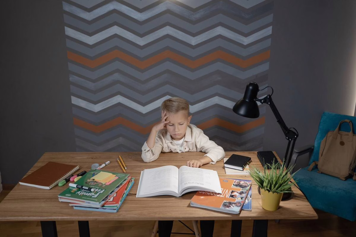Enfant qui écrit dans un cahier lors d'un stage de réussite en petit groupe pendant les vacances
