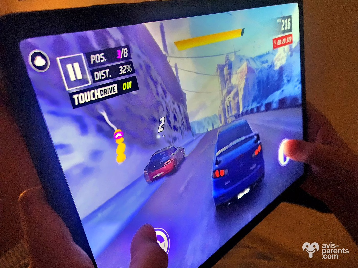 Partie du jeu de course Asphalt sur la Samsung Galaxy Tab S11 tenue à deux mains par un enfant