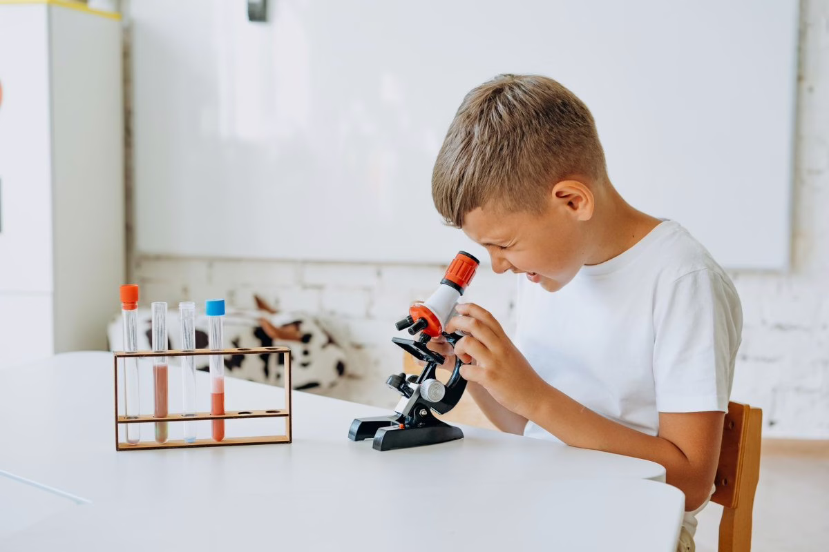 Garçon de 9 ans qui observe au microscope
