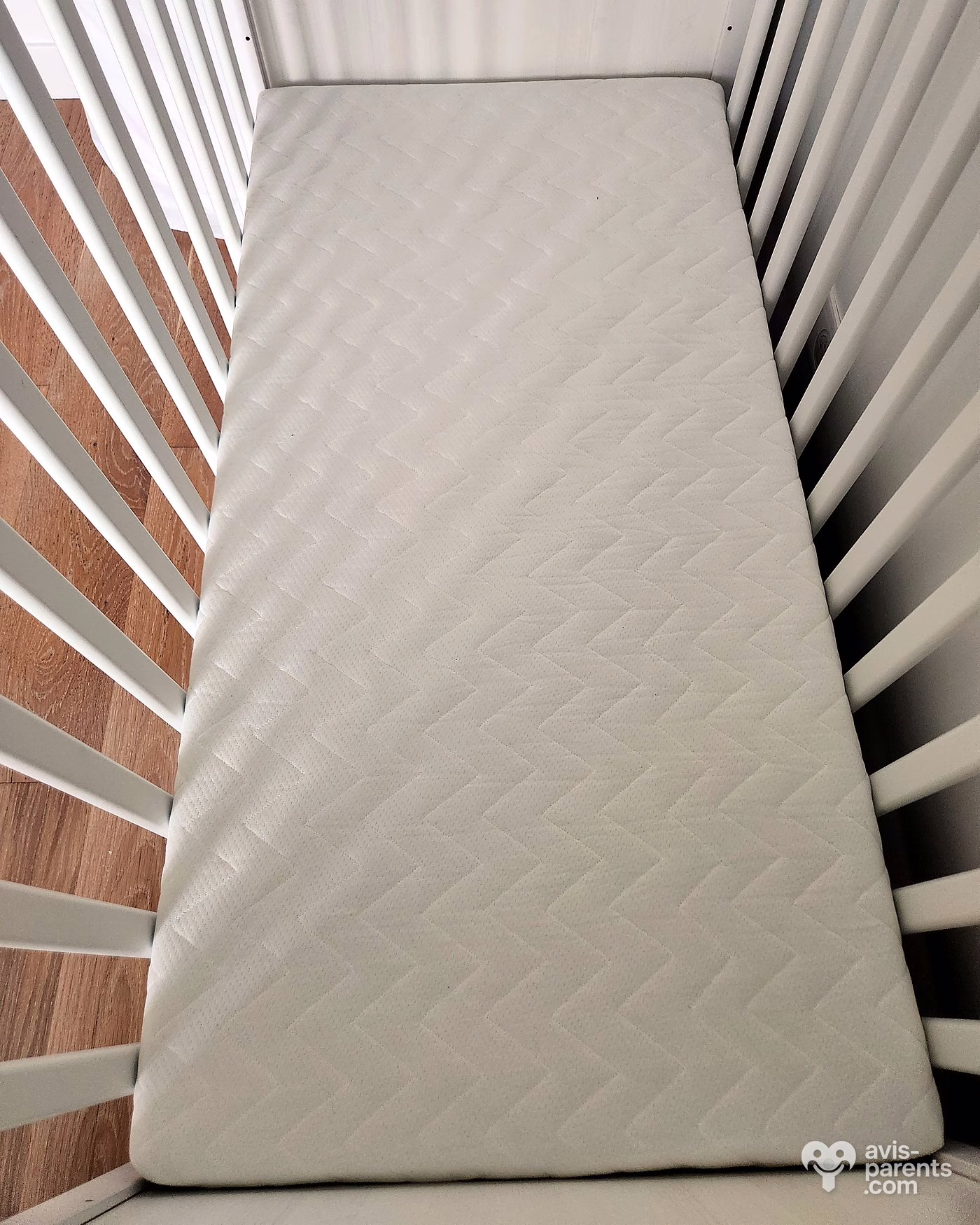 Matelas bébé Tediber Tedi vu de dessus dans un lit à barreaux, sans drap